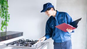 Technician inspecting kitchen baseboards for roach activity